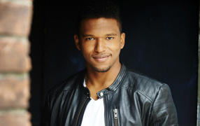 Красивый мужчина в черной куртке, актер Ловелл Адамс-Грей