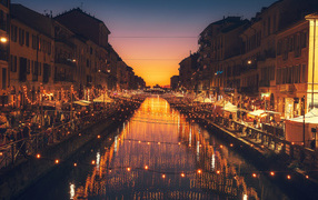 Яркие зажженные лампы над водным каналом