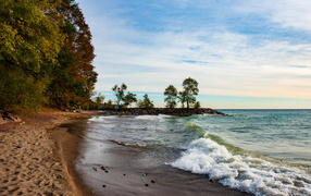 Белые волны океана на мокром песке под красивым небом
