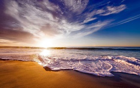 Красивые белые морские волны на теплом песке летом