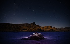 Desert in the mountains under a starry night sky