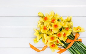 Букет желтых нарциссов с бантом на сером фоне