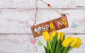 Букет желтых тюльпанов на деревянном фоне с надписью Весна 