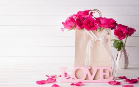 Пакет с розами на столе с надписью Love