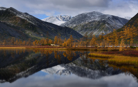 Горы отражаются в глади воды озера осенью