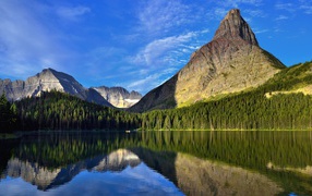 Каменные горы под голубым небом отражаются в воде