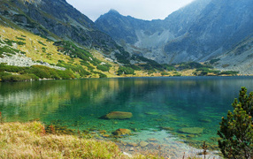 Озеро с чистой водой у подножия высоких гор