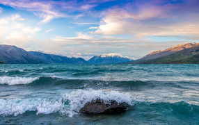The waves beat against the rocks in the bay by the mountains
