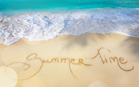 Надпись время лета на песке у моря