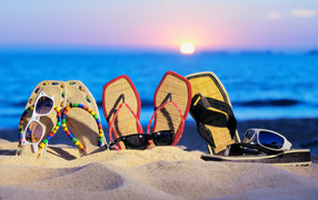 Slippers and sunglasses on the beach in summer