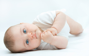 Funny blue-eyed baby on a white background