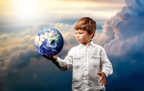 Маленький мальчик с планетой земля в руке