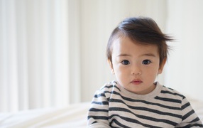 Маленький кареглазый мальчик в полосатом свитере