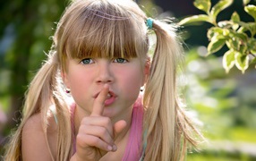 Маленькая зеленоглазая девочка с пальцем у рта 
