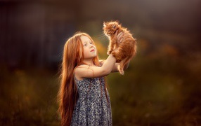 Маленькая рыжеволосая девочка с рыжим котенком в руках