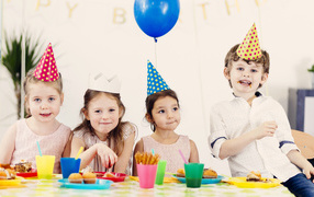 Маленькие дети отмечают детский праздник за столом