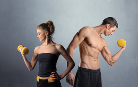 Девушка и парень занимаются спортом с гантелями