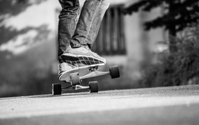 The guy rides a skateboard on asphalt