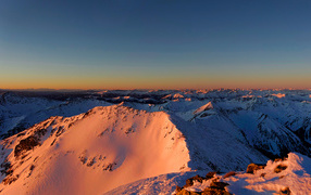 Заснеженные верхушки гор с лучах яркого солнца
