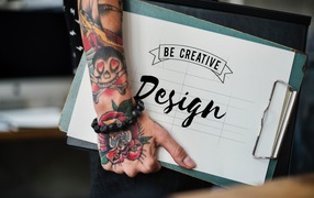 Мужчина с татуировкой на руке держит папку