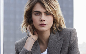 Actress Cara Delevingne in a jacket with a tattoo on her arm