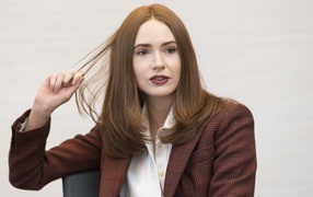 Актриса Карен Гиллан в пиджаке держит волосы