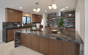 Красивая коричневая кухня с гранитными столами
