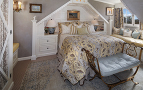 Спальня с большой просторной кроватью и диваном у окна 