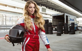 Девушка гонщица с шлемом в руках