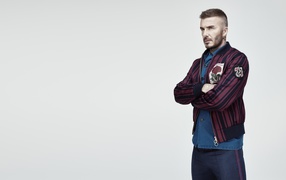 Handsome male football player and model David Beckham on gray background