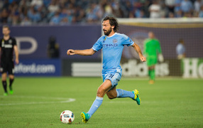 Итальянский футболист Андреа Пирло отбивает мяч на футбольном поле