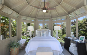 Большая спальная комната с окнами и белой кроватью 