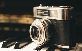 Старый фотоаппарат Zeiss Ikon стоит на клавишах пианино