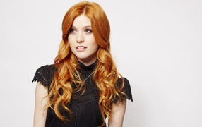 Red-haired girl, actress Katherine McNamara on a gray background