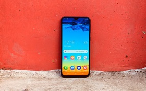 Smartphone Samsung Galaxy M20 on the red wall