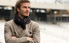 Soccer player David Beckham in a suit with a scarf around his neck