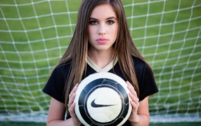 Sports girl goalkeeper with the ball in the goal