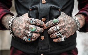 Tattoos on the hands of men with rings