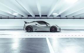 Серый автомобиль Pogea Racing Nemesis 2020 года на парковке 