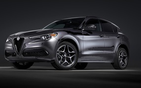 Серебристый автомобиль Alfa Romeo, 2020 года на сером фоне