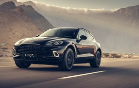 Черный автомобиль Aston Martin DBX 2020 года на трассе