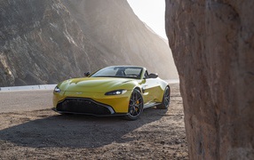 Желтый автомобиль  Aston Martin Vantage Roadster, 2021 года в горах 