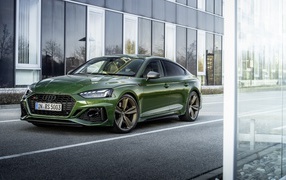 Зеленый автомобиль Audi RS 5 Sportback 2020 года у здания 