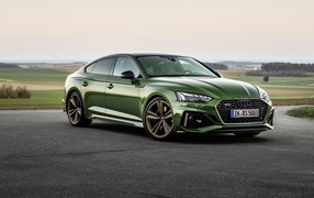 Green car Audi RS 5 Sportback 2020 on the background of the field