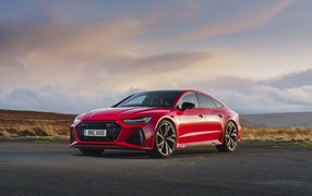 Красный автомобиль Audi RS 7 Sportback 2020 года на дороге 