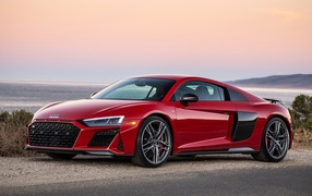 Красный спортивный автомобиль Audi R8 V10, 2020 года на фоне океана