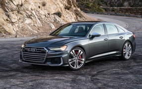 Серебристый седан  Audi S6, 2020 года на повороте 
