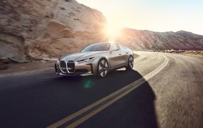 Автомобиль BMW Concept I4 2020 года у гор в лучах солнца