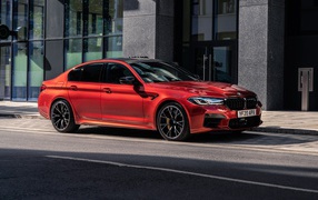 Красный автомобиль BMW M5 Competition 2020 года у дома