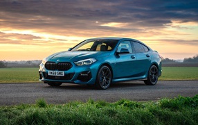 Синий автомобиль BMW 218i Gran Coupe M Sport 2020 года на фоне заката